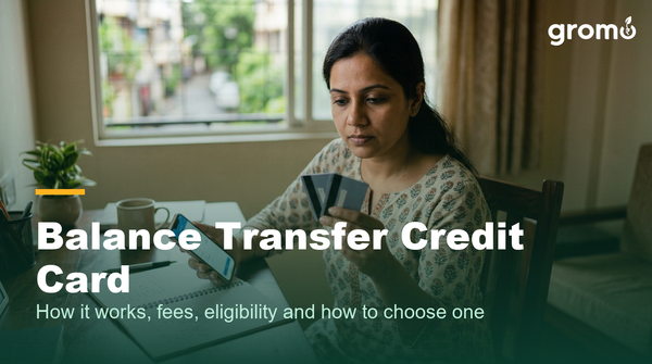 Indian woman comparing two credit cards while planning a balance transfer on her phone