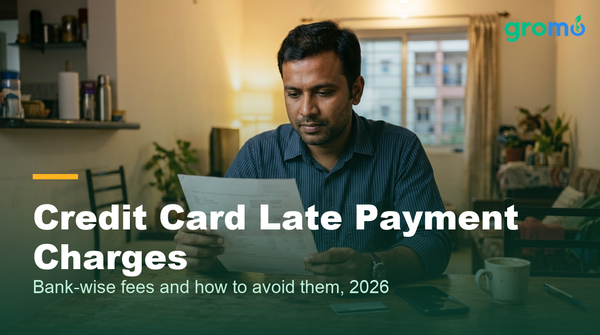 Indian man reviewing credit card late payment charges on his bill at home