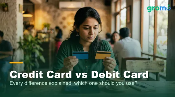 Indian woman comparing a credit card and a debit card side by side