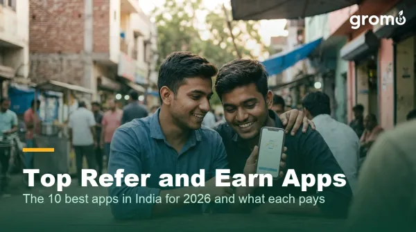 Two young Indian friends sharing a refer and earn app link on a smartphone